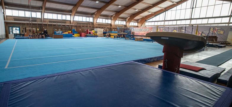 Wnętrze hali sportowej wyłożone materacami i matami gimnastycznymi.
